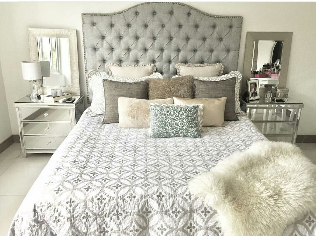 Cama con cabecero tapizado en capitoné gris hecha a medida
