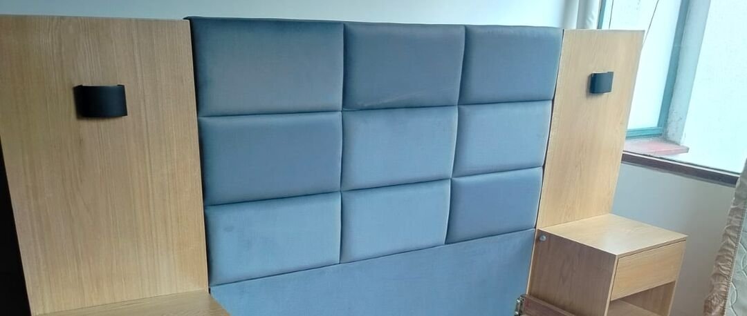 Espaldar de cama tapizado en paneles azules con mesas de noche de madera, hecho a la medida