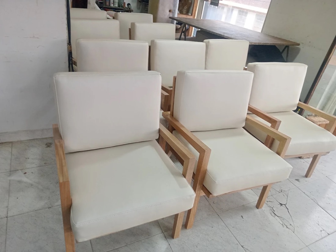 Sillas tapizadas en tela blanca con estructura de madera, fabricadas en nuestro taller de Bogotá
