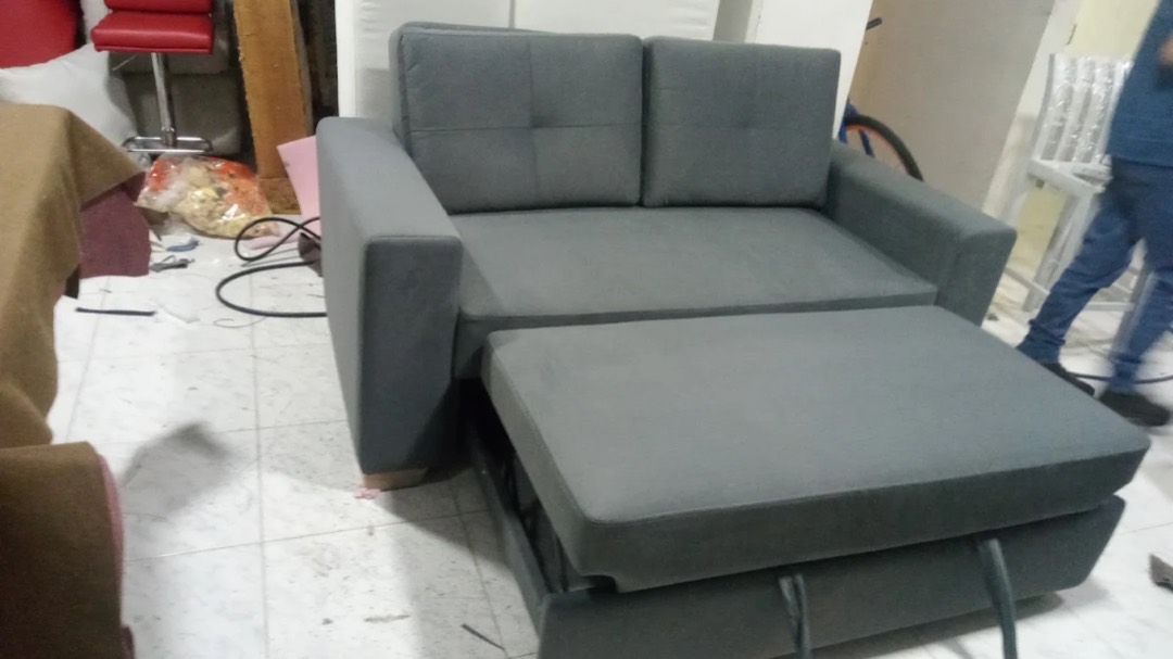 Sofá cama gris con la cama auxiliar extendida, fabricado en nuestro taller de Bogotá